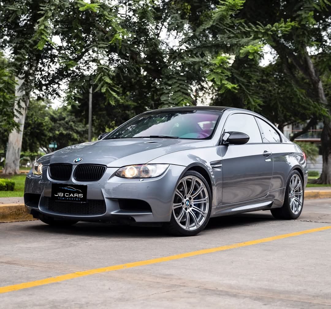 Auto deportivo rojo estacionado en calle con árboles